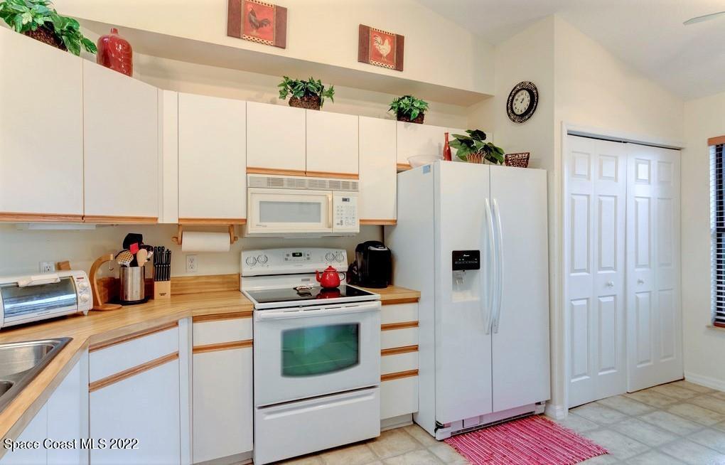 Undisclosed Address Sebastian, FL 32958 - Photo 20 of 33 a kitchen with refrigerator a stove a microwave and cabinets