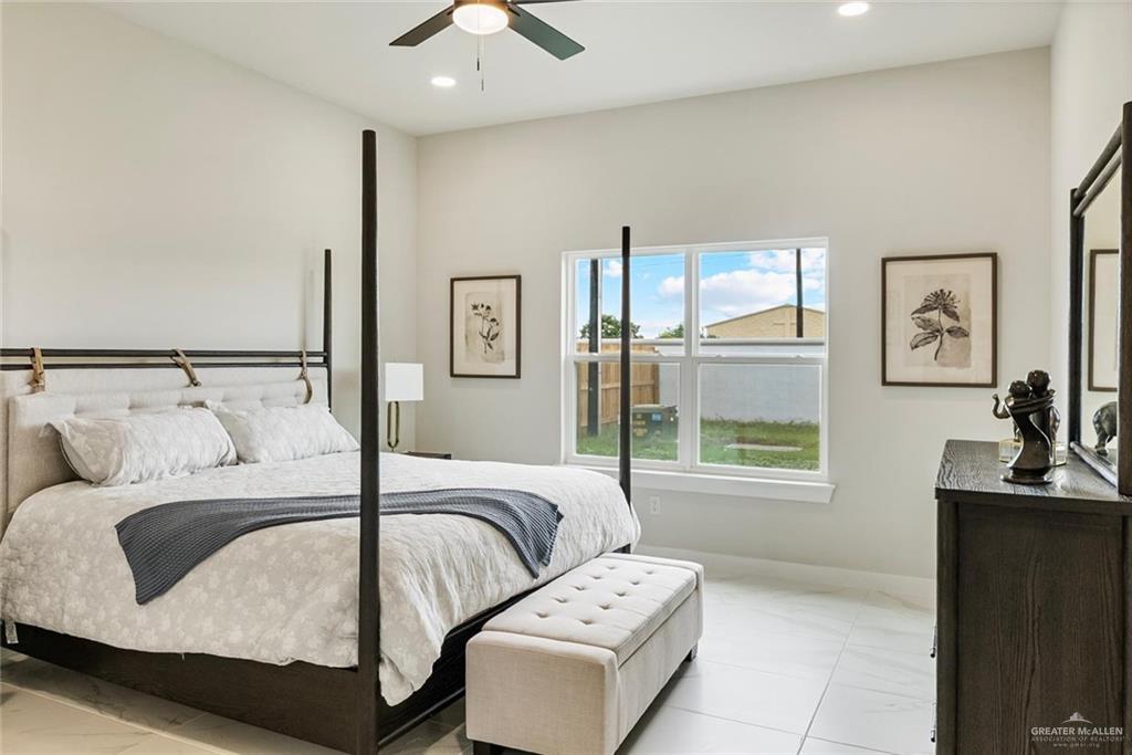 3501 Kerps Street Weslaco, TX 78599 - Photo 8 of 12 a bedroom with a large bed and a chandelier