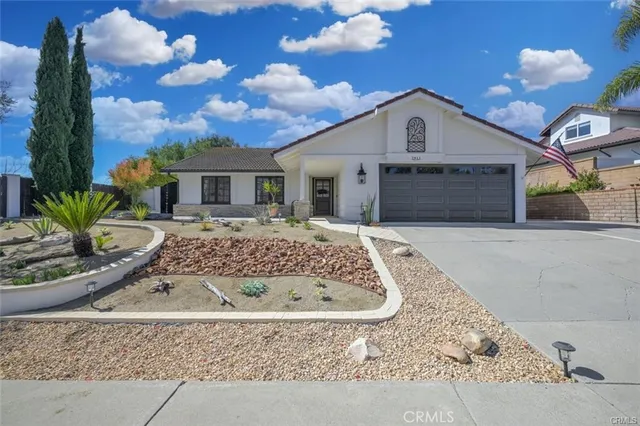 a view of a white house with a yard and potted plants