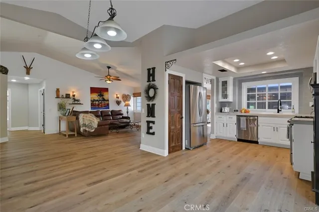 a kitchen with a refrigerator a stove top oven a sink dishwasher and wooden cabinets
