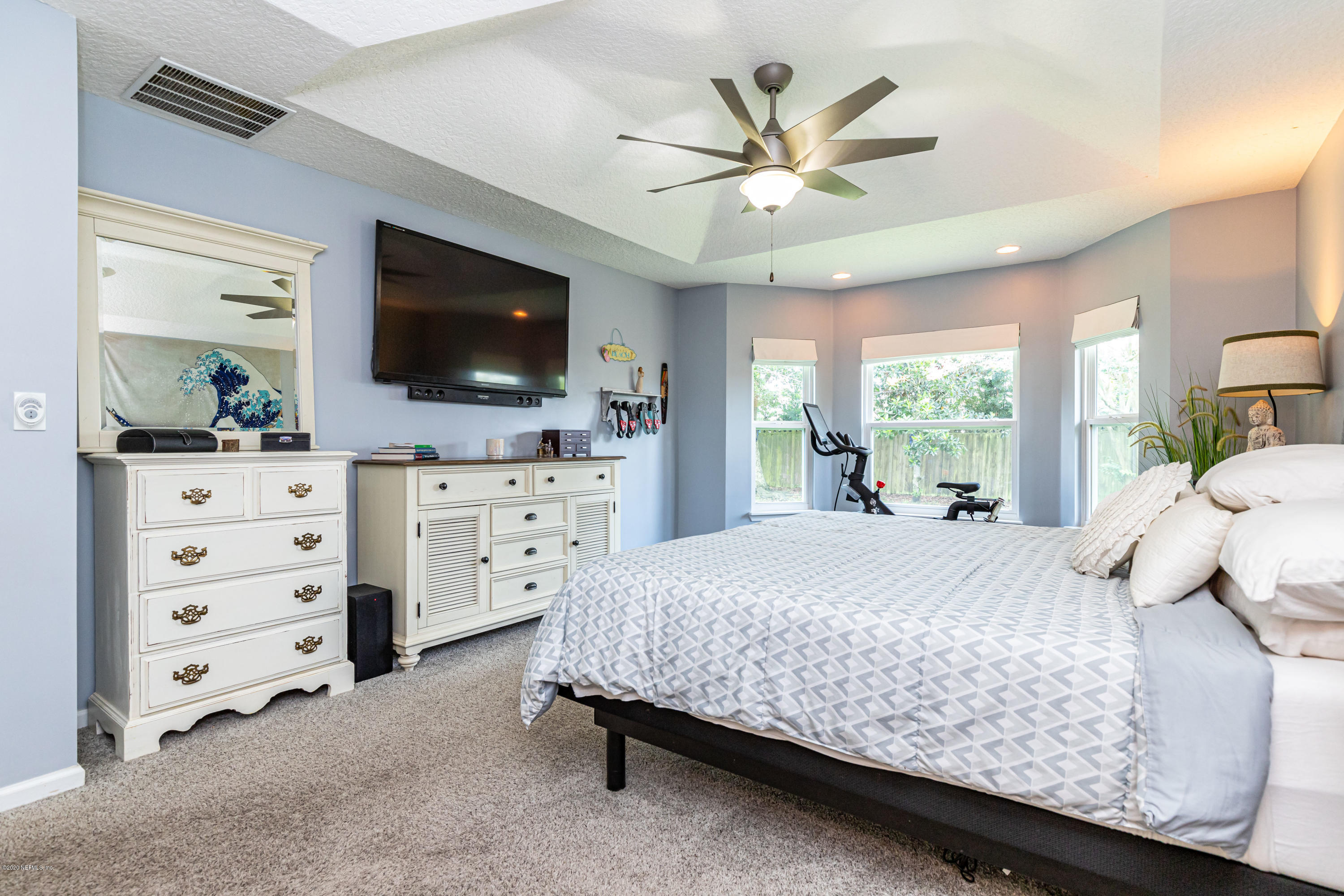 951 Silver Spring Court St. Augustine, FL 32092 - Photo 23 of 40 a bedroom with a bed a flat screen tv and a chandelier