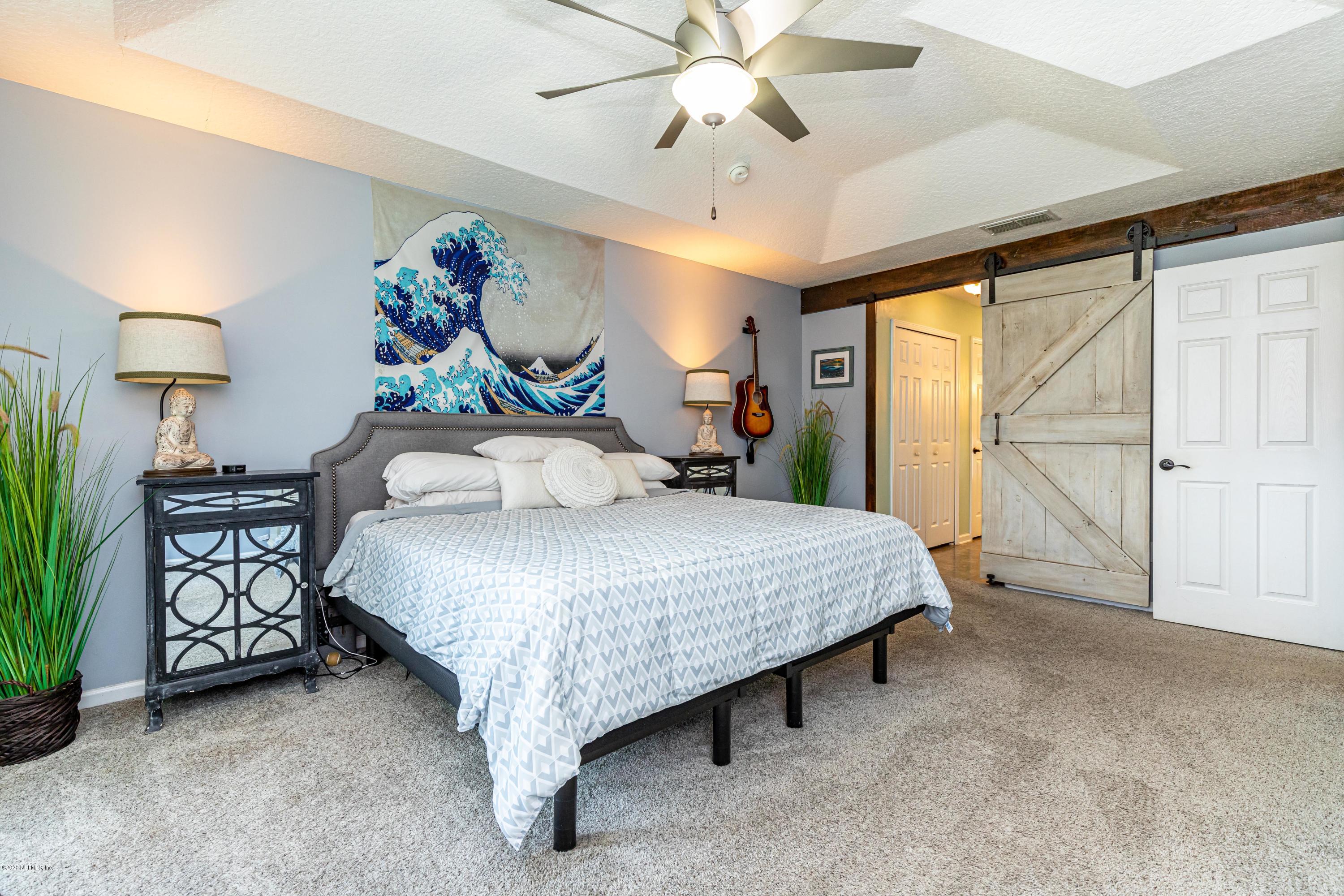 951 Silver Spring Court St. Augustine, FL 32092 - Photo 24 of 40 a spacious bedroom with a bed and a chandelier