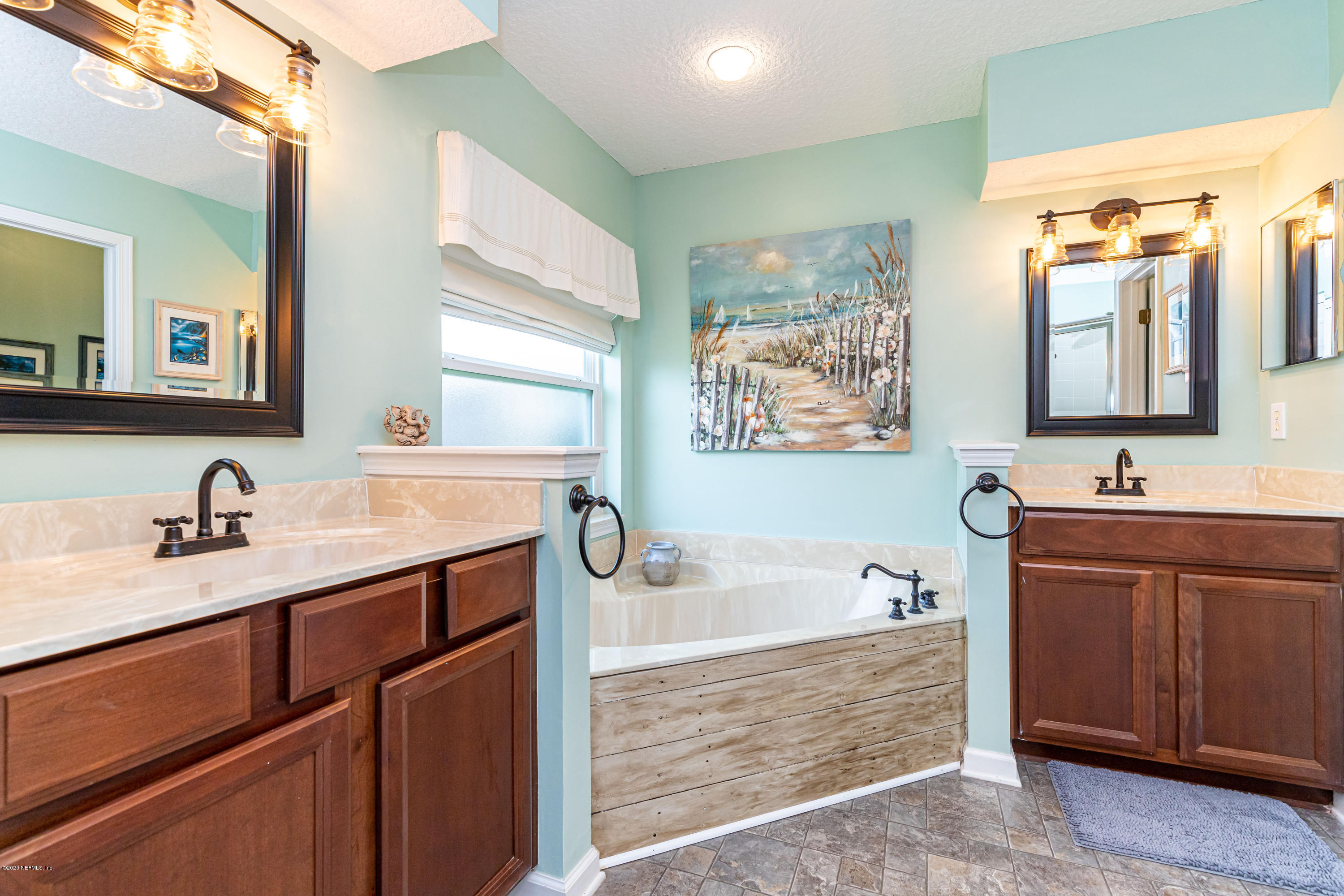 951 Silver Spring Court St. Augustine, FL 32092 - Photo 26 of 40 a bathroom with a tub a sink double vanity and mirror