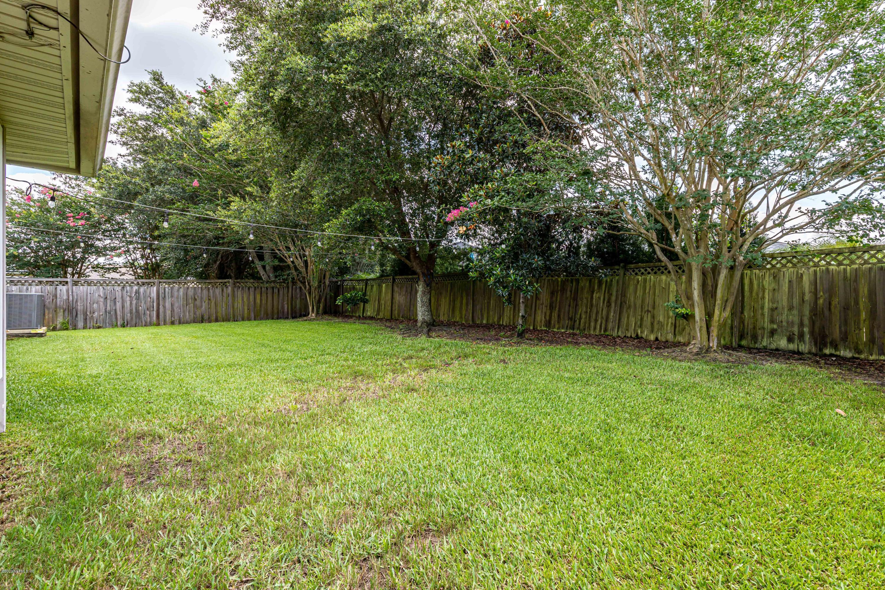 951 Silver Spring Court St. Augustine, FL 32092 - Photo 36 of 40 a view of a backyard with large trees and wooden fence