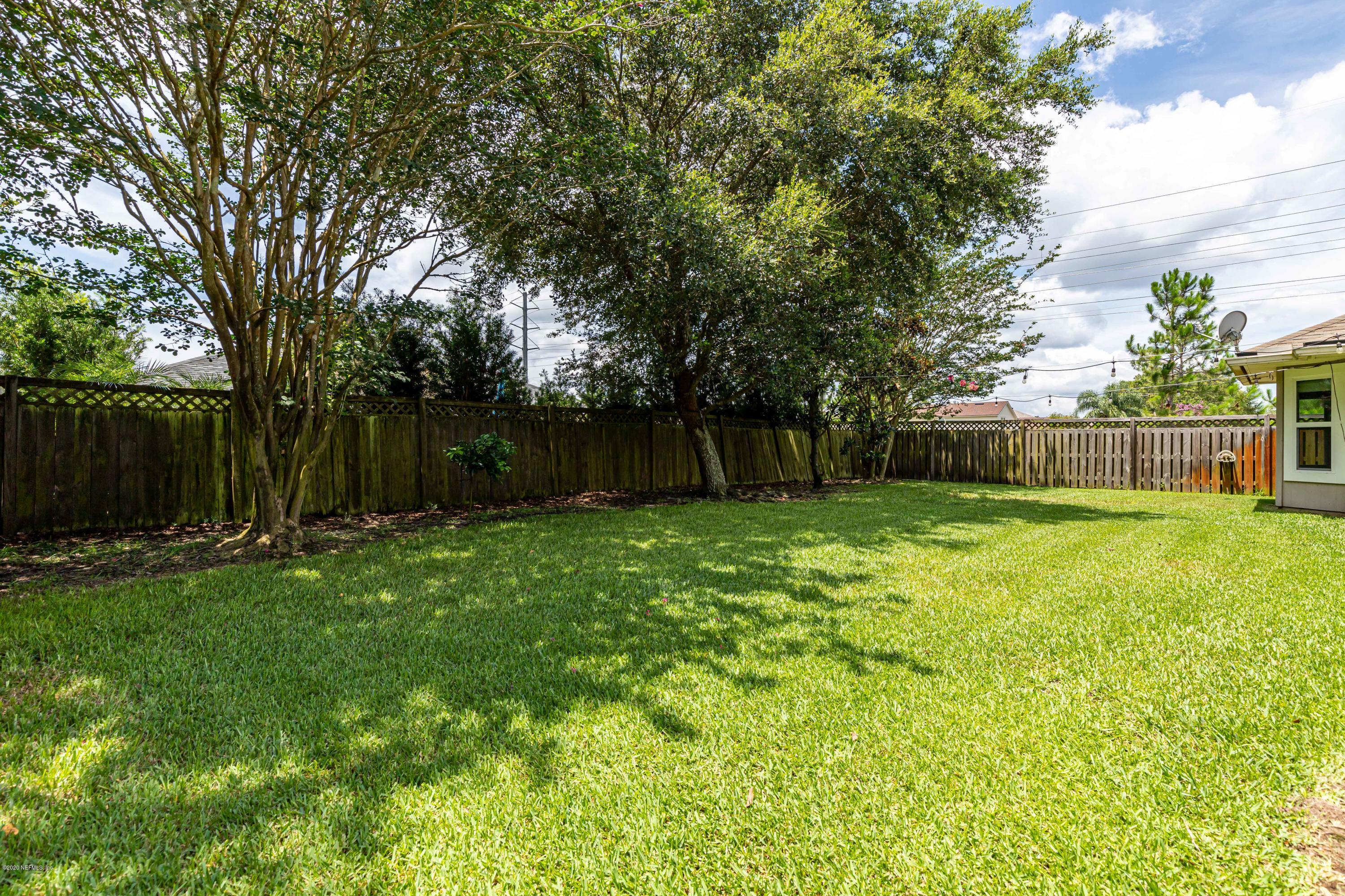 951 Silver Spring Court St. Augustine, FL 32092 - Photo 40 of 40 a view of a backyard with table and chairs and wooden fence