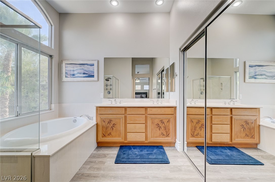 2391 Rainswept Avenue Henderson, NV 89052 - Photo 38 of 62 This serene bathroom offers a luxurious soaking tub, dual vanities, and ample natural light.