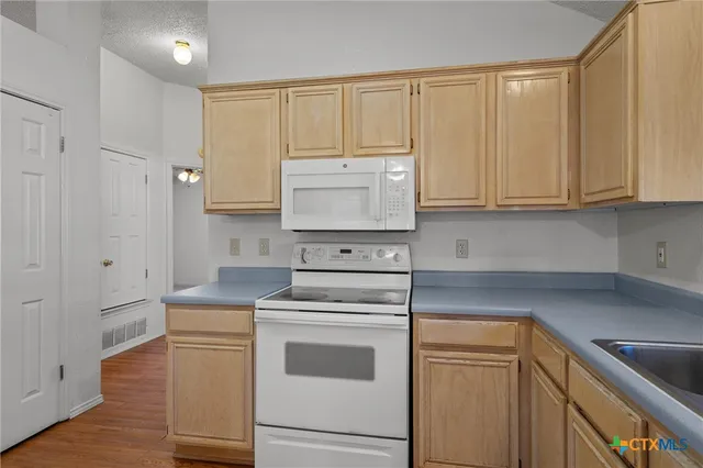 a kitchen with white cabinets and white appliances