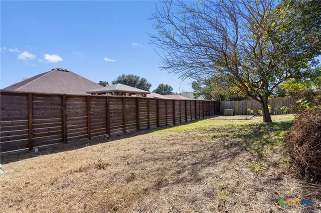 a view of wooden fence next to a yard