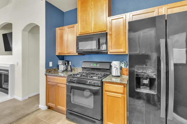 a kitchen with stainless steel appliances granite countertop a refrigerator and a sink