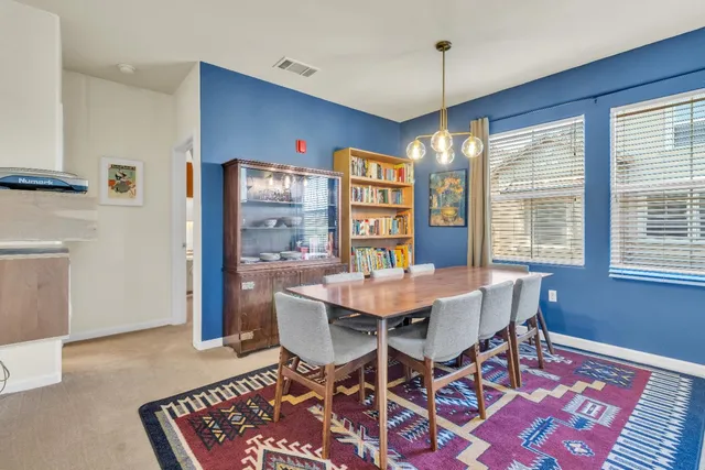 a living room with furniture a flat screen tv and kitchen view