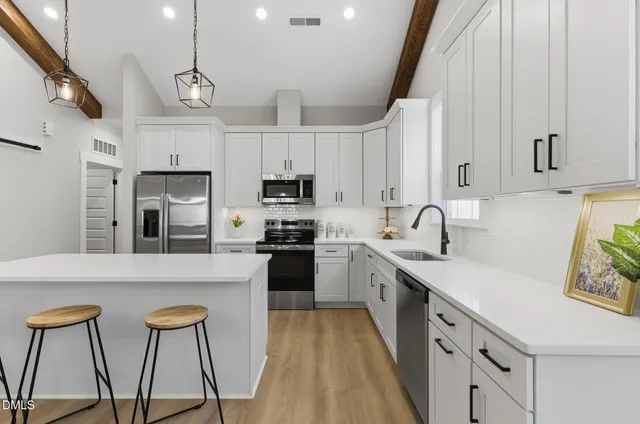 a kitchen with stainless steel appliances granite countertop a sink a stove and refrigerator