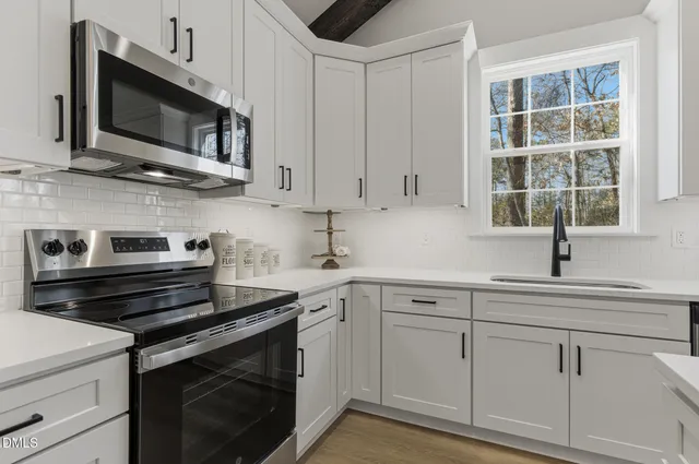 a kitchen with cabinets stainless steel appliances and window
