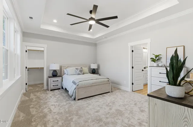 a spacious bedroom with a bed and a potted plant