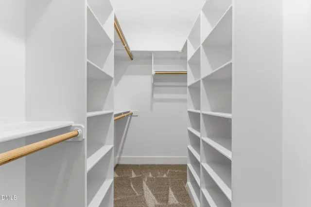 a view of walk in closet with empty racks