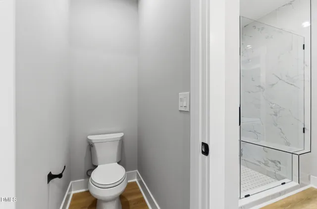 a white toilet sitting next to a shower
