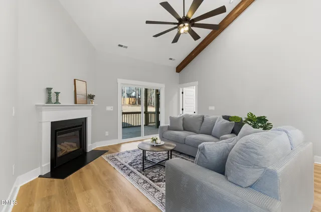 a living room with furniture a fireplace and a ceiling fan