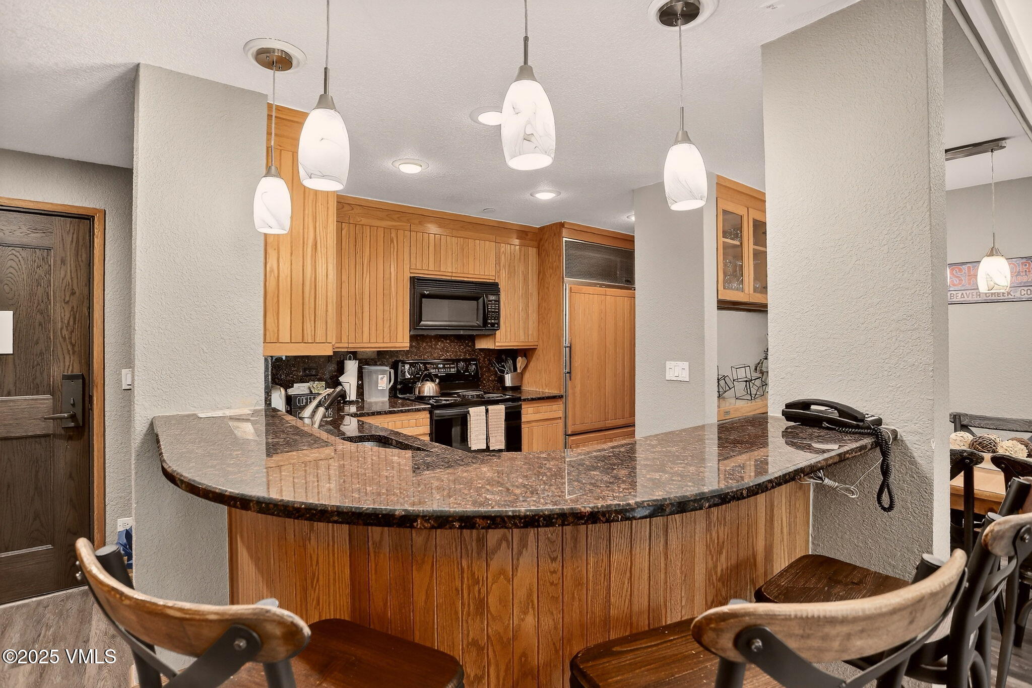120 Offerson Road, Unit 5160 Beaver Creek, CO 81620 - Photo 6 of 30 a kitchen with kitchen island granite countertop a table chairs sink and microwave