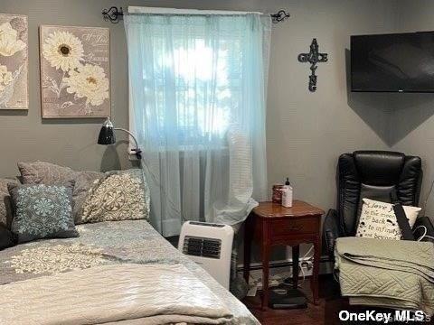 721 Meadow Road Smithtown, NY 11787 - Photo 4 of 10 a bedroom with a bed and a chair