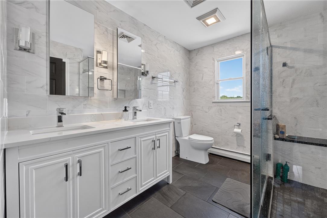 220 Pennbrook Road Stroudsburg, PA 18360 - Photo 28 of 60 A well-lit primary bathroom features a dual vanity, a spacious shower, and elegant tile work throughout.