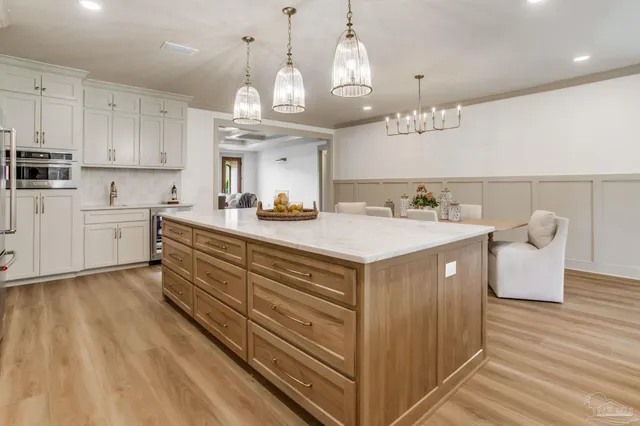 a kitchen with kitchen island granite countertop a sink cabinets and wooden floor