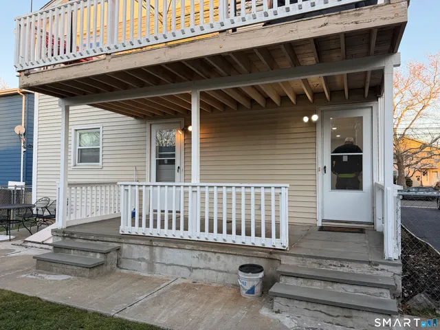 a view of a patio with table and chairs with wooden floor and fence