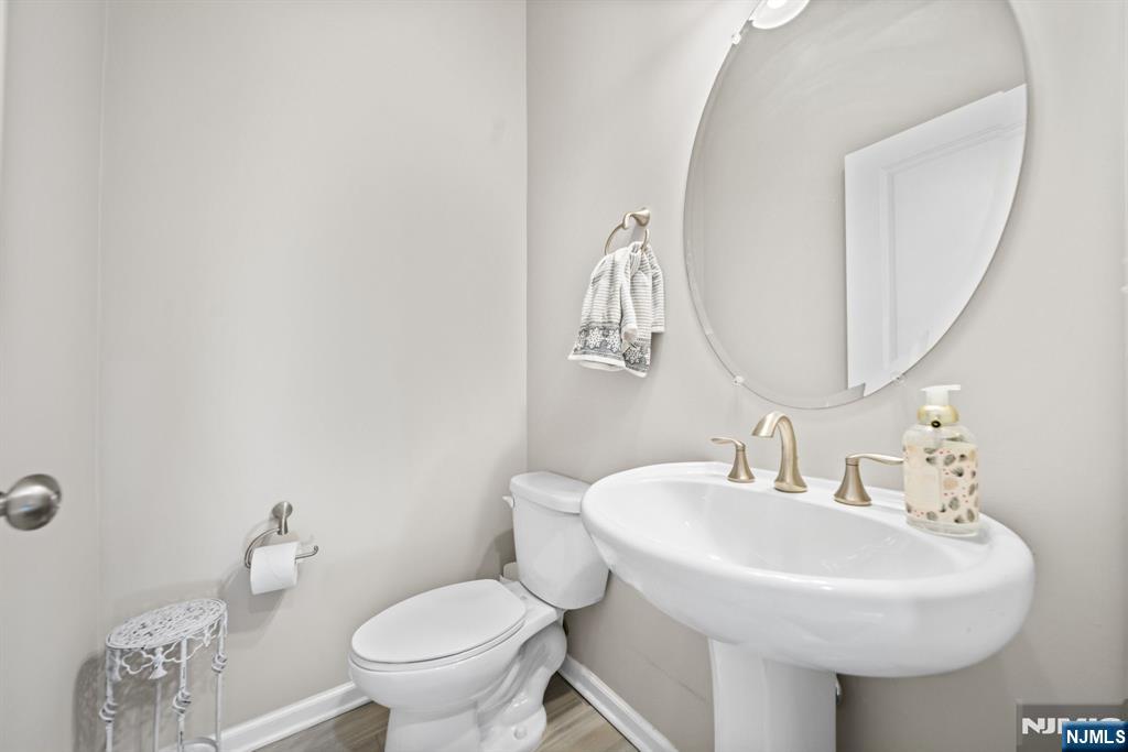 84 Truman Drive, Unit 2801 Wood-Ridge, NJ 07075 - Photo 11 of 46 a bathroom with a toilet sink and mirror