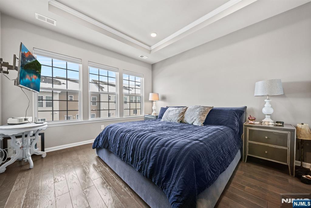 84 Truman Drive, Unit 2801 Wood-Ridge, NJ 07075 - Photo 23 of 46 a bedroom with a bed and wooden floor