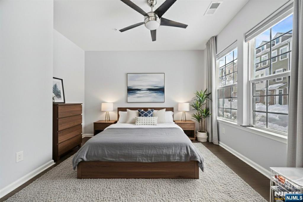 84 Truman Drive, Unit 2801 Wood-Ridge, NJ 07075 - Photo 4 of 46 a bedroom with a large bed and a chandelier fan