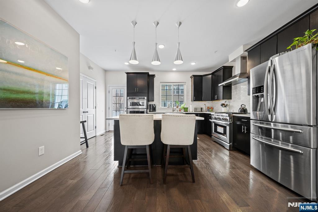 84 Truman Drive, Unit 2801 Wood-Ridge, NJ 07075 - Photo 6 of 46 a kitchen with stainless steel appliances a dining table chairs microwave and sink