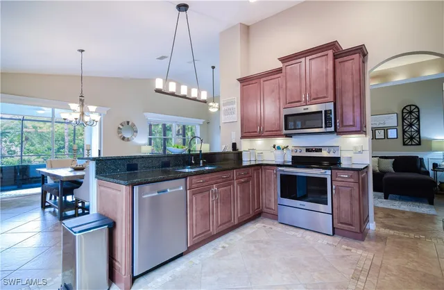 a kitchen with stainless steel appliances granite countertop a stove a sink and a wooden floors