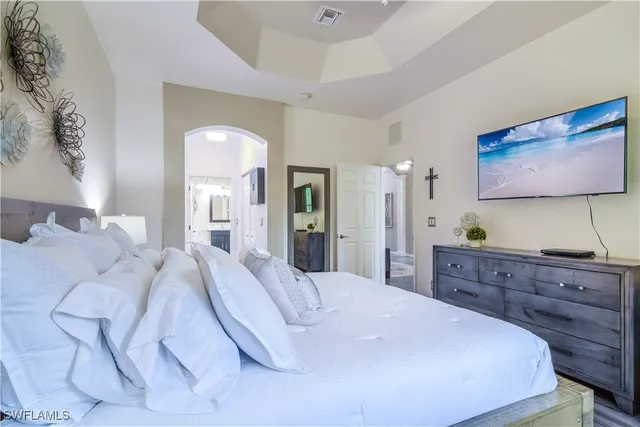 a spacious bedroom with a bed and a dresser