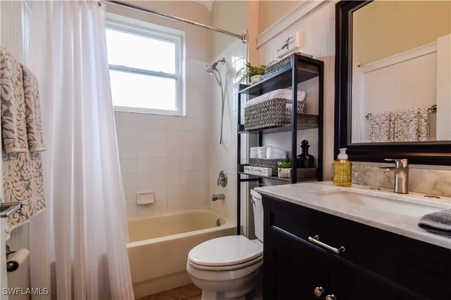 a bathroom with a granite countertop sink toilet a large mirror and a bathtub