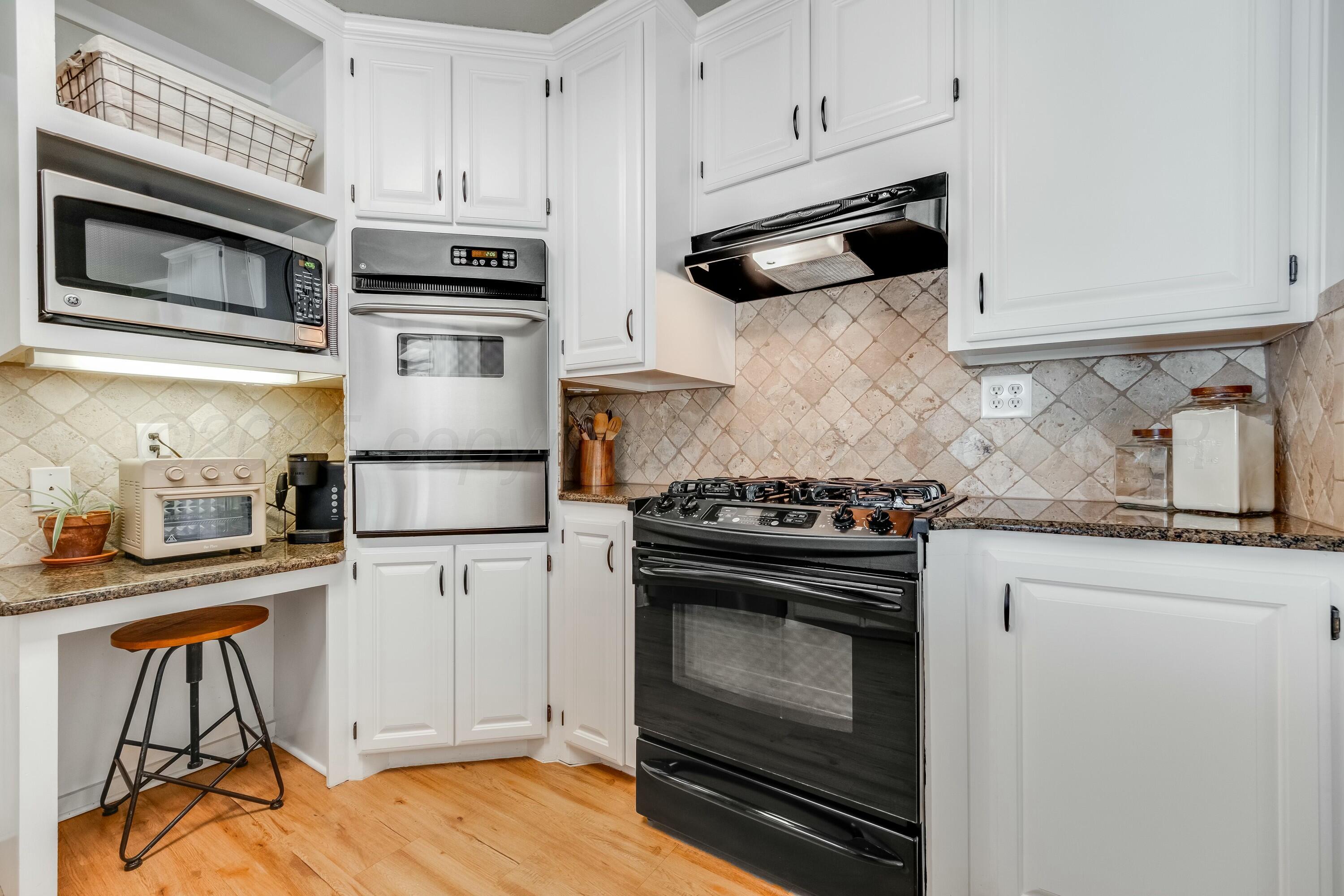 3128 Nebraska Street Amarillo, TX 79106 - Photo 11 of 34 a kitchen with cabinets stainless steel appliances and wooden floor