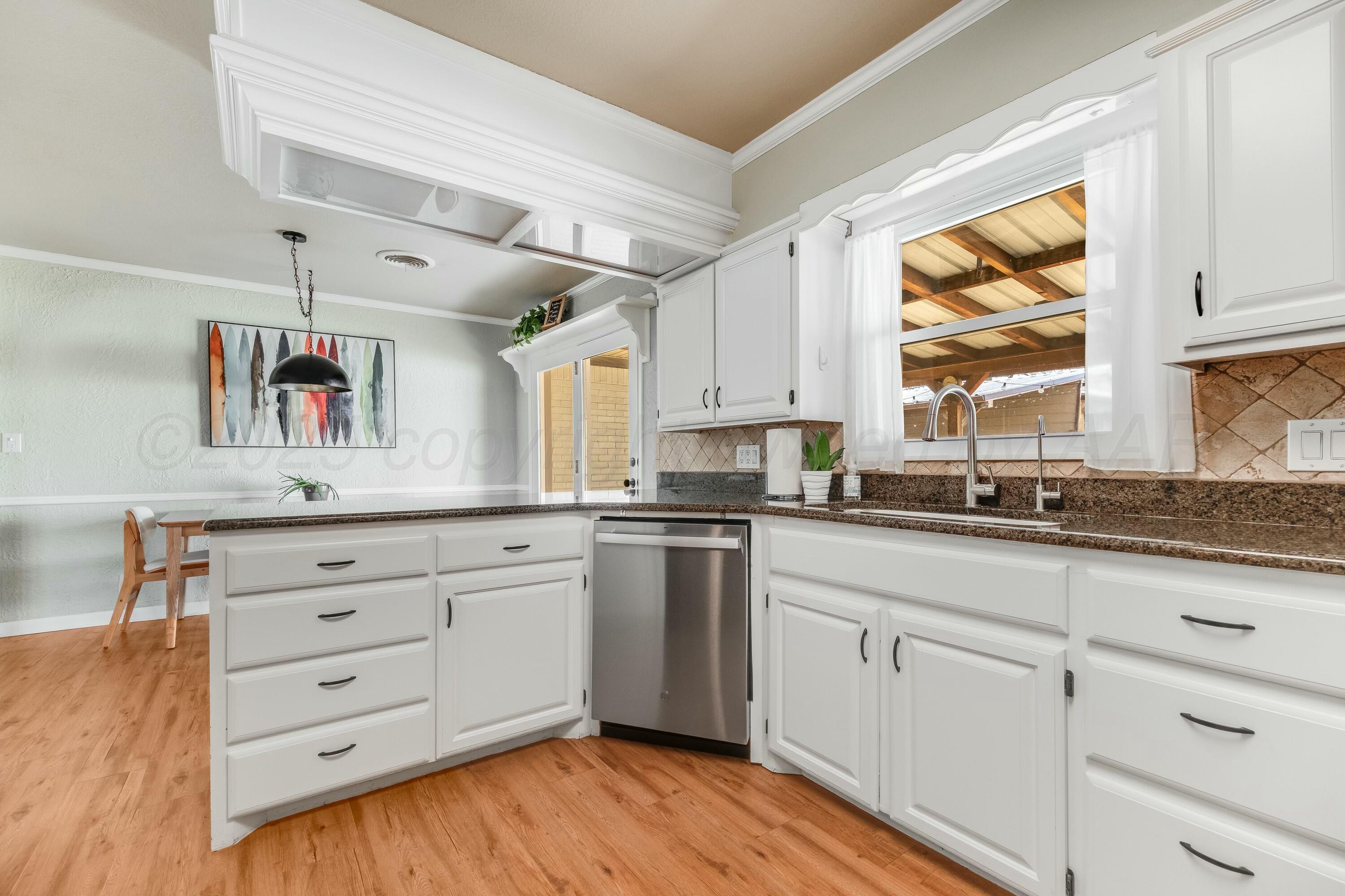 3128 Nebraska Street Amarillo, TX 79106 - Photo 13 of 34 a kitchen with cabinets wooden floor and white appliances
