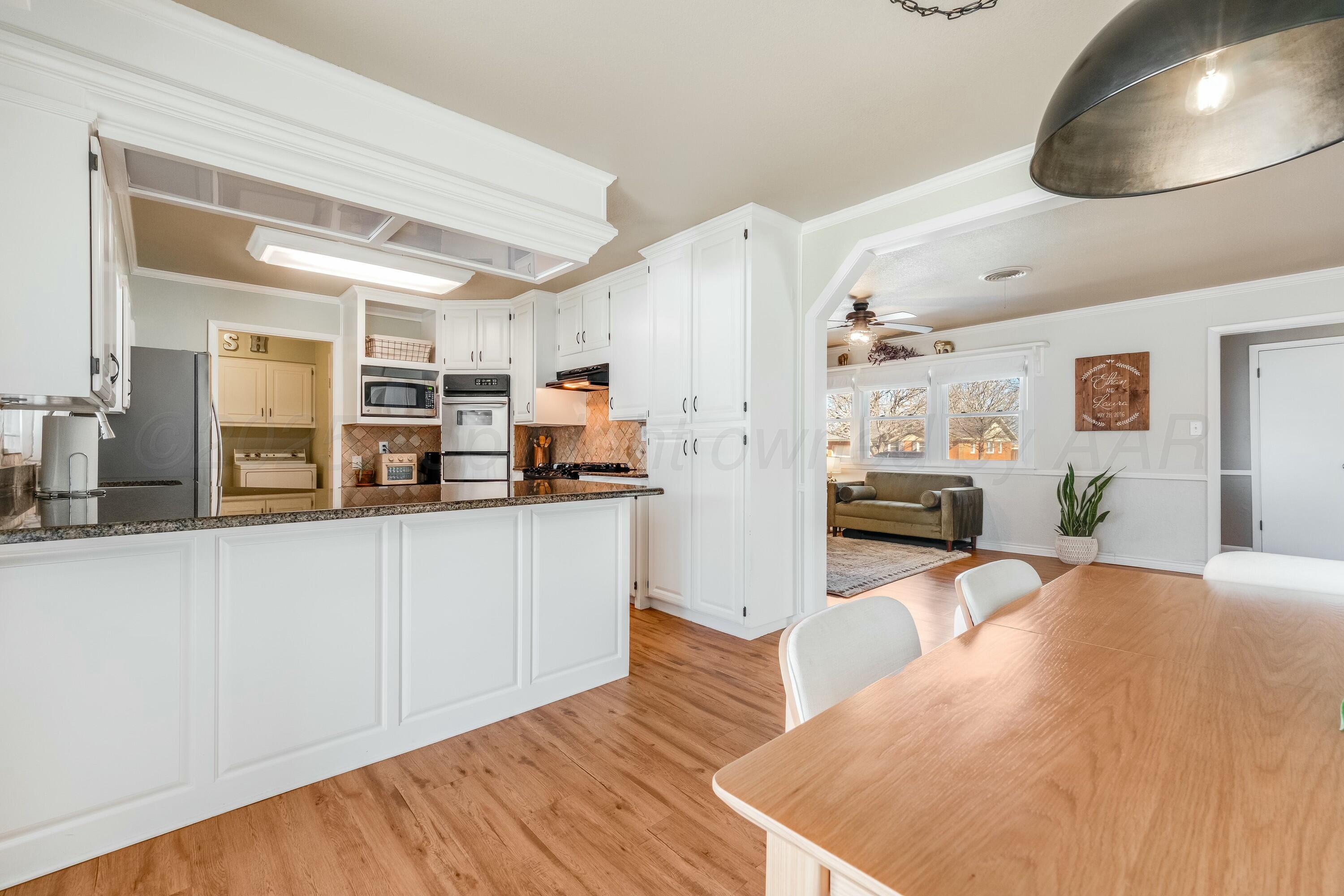 3128 Nebraska Street Amarillo, TX 79106 - Photo 14 of 34 a kitchen with stainless steel appliances a refrigerator and a wooden floor