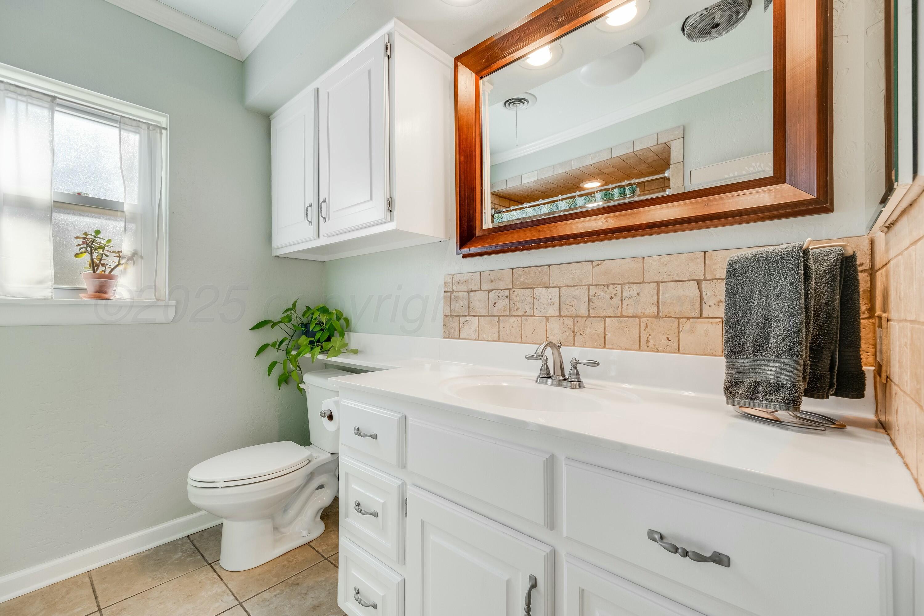 3128 Nebraska Street Amarillo, TX 79106 - Photo 22 of 34 a bathroom with a toilet sink and mirror