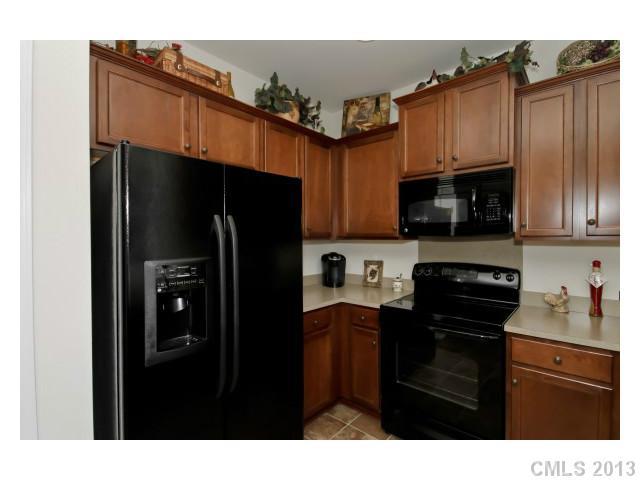 3342 Streamside Drive Davidson, NC 28036 - Photo 7 of 16 a kitchen with stainless steel appliances granite countertop a refrigerator a stove top oven and a sink