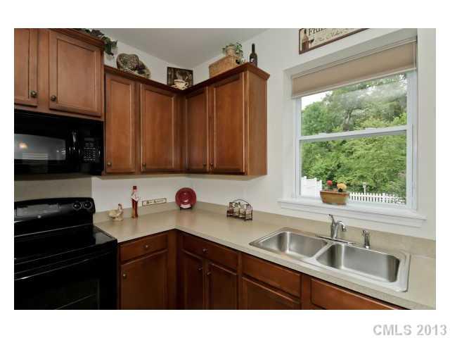 3342 Streamside Drive Davidson, NC 28036 - Photo 8 of 16 a kitchen with granite countertop a sink cabinets stainless steel appliances and a window