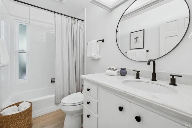 a bathroom with a sink a toilet and a mirror