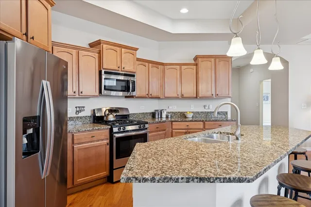 a kitchen with stainless steel appliances granite countertop a refrigerator stove and sink