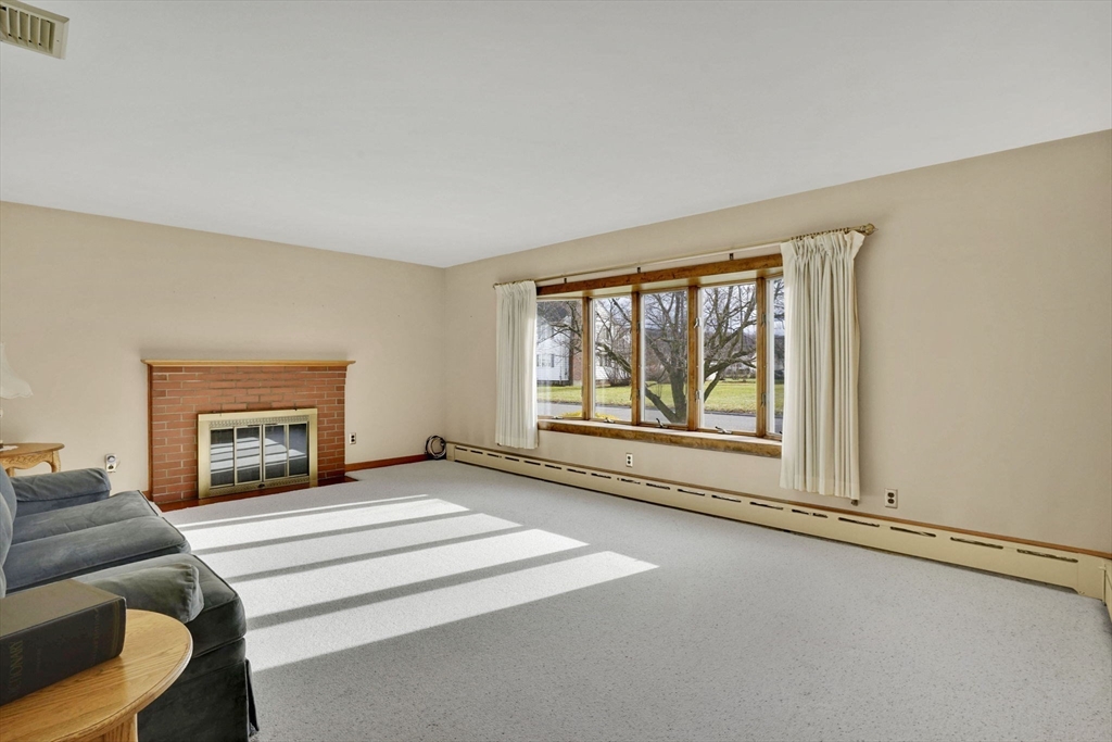 76 Roy Street Chicopee, MA 01013 - Photo 15 of 30 a view of an empty room with a fireplace and a window