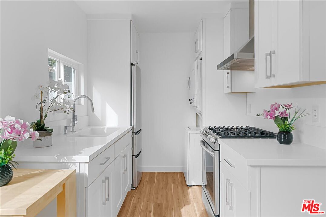 2948 Exposition Boulevard, Unit 5 Santa Monica, CA 90404 - Photo 8 of 13 a kitchen with white cabinets and a sink