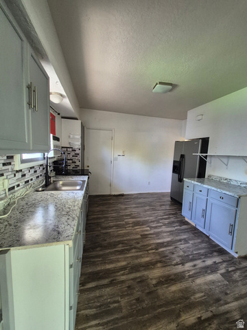 327 North 300 West Logan, UT 84321 - Photo 3 of 12 Kitchen featuring backsplash, stainless steel refrigerator with ice dispenser, a textured ceiling, and dark wood-style flooring