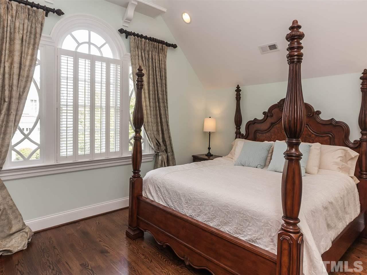 416 Wayne Drive Raleigh, NC 27608 - Photo 16 of 25 a bedroom with a bed and a chandelier