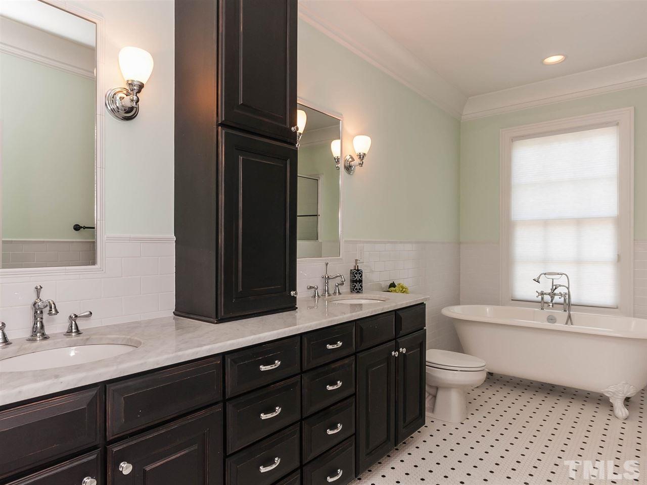 416 Wayne Drive Raleigh, NC 27608 - Photo 17 of 25 a bathroom with a double vanity sink a mirror and a bathtub