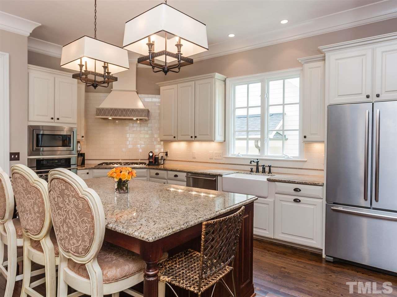 416 Wayne Drive Raleigh, NC 27608 - Photo 9 of 25 a kitchen with stainless steel appliances granite countertop a stove a refrigerator a kitchen island a sink dishwasher a dining table and chairs with wooden floor