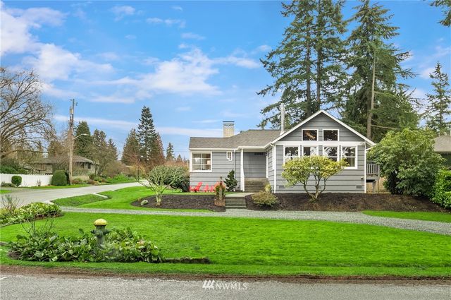 a front view of a house with a yard and potted plants