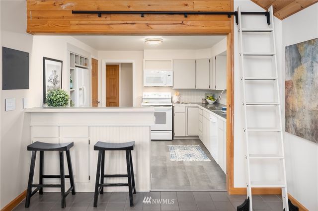 a kitchen with a table chairs refrigerator and cabinets