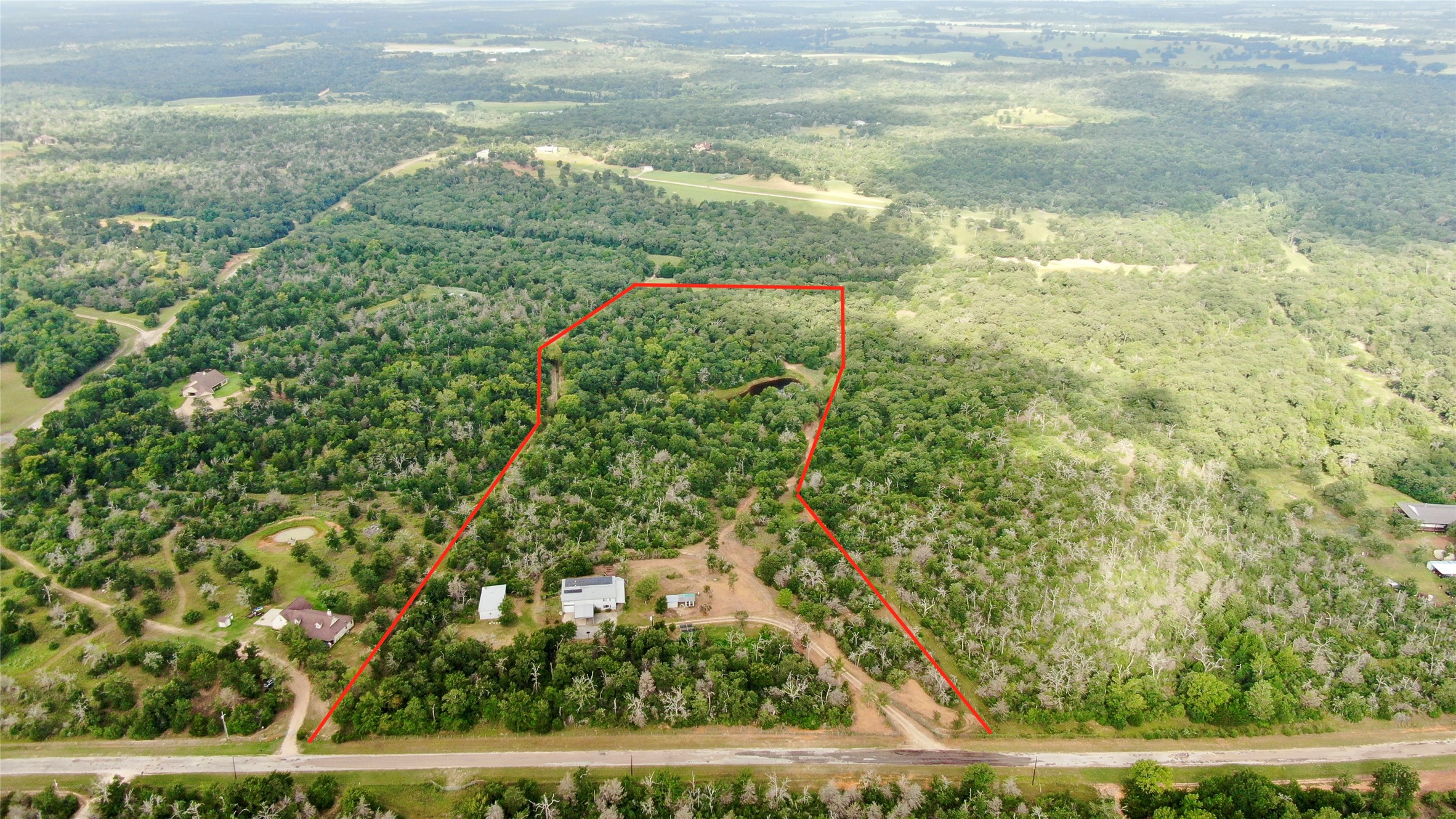 1004 22 Hills Road Gause, TX 77857 - Photo 18 of 37 A winding road borders this expansive, wooded lot, featuring a pond and clear boundaries for your private retreat.