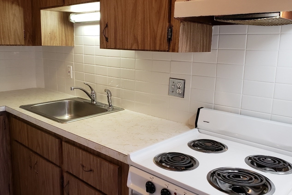 924 Beacon Street, Unit 6 Boston, MA 02215 - Photo 14 of 28 a kitchen with a sink a stove and cabinets